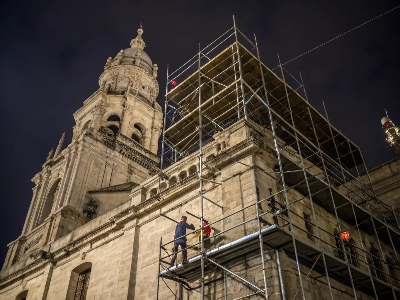 A photograph of a historic building undergoing careful restoration, showcasing the preservation of original architectural details and craftsmanship by Mokas.